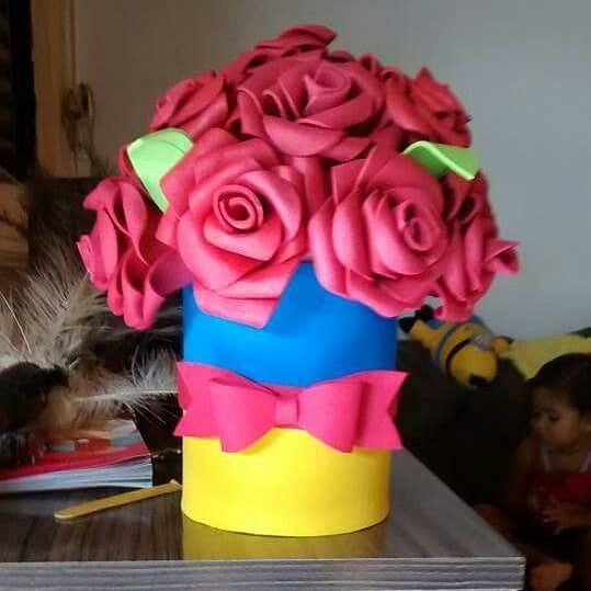 Centro de mesa Branca de Neve com buquê de flores vermelhas em EVA sobre base colorida azul, amarela e vermelha.