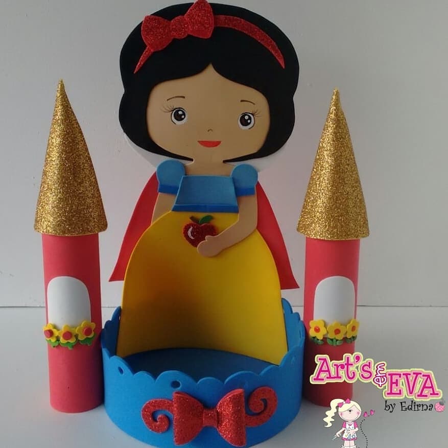 Centro de mesa infantil em EVA com tema Branca de Neve, com personagem em destaque e torres de castelo com glitter dourado, ideal para festas de princesas.