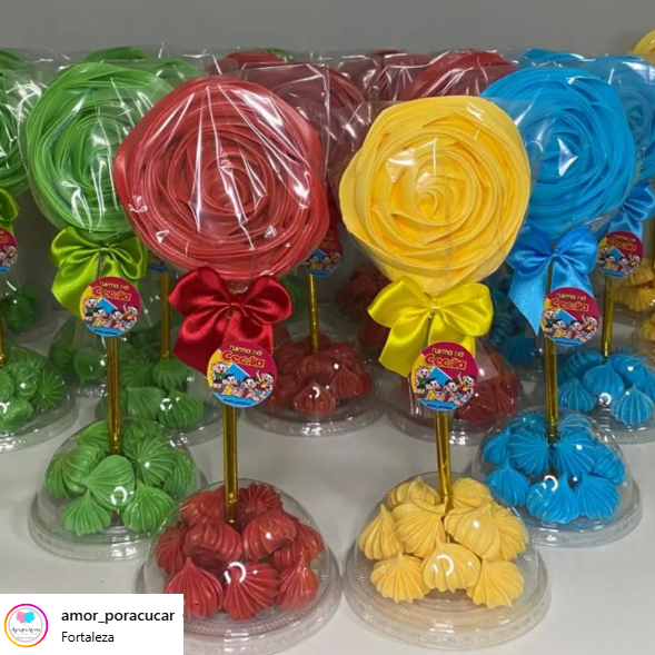 Centro de mesa com pirulito decorativo e base de merengues coloridos, embalado com laço de cetim
