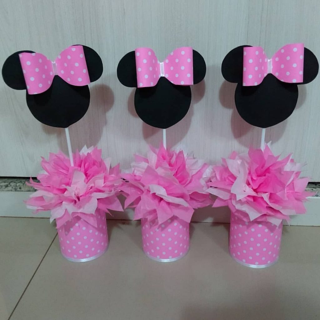 Centro de mesa da Minnie rosa com laço de poá e base decorada com papel de seda e EVA.