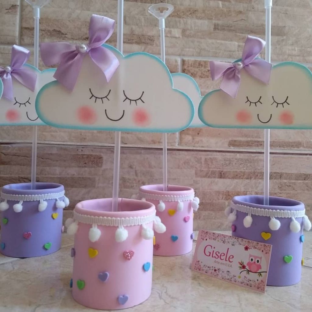 Centros de mesa com nuvens em EVA, decoradas com lacinhos e corações coloridos, para festa infantil delicada.