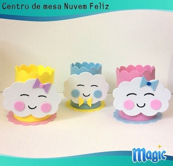 Centros de mesa em EVA com nuvens felizes e coloridas, decoradas com laços e expressões sorridentes, para festas infantis ou chás de bebê.