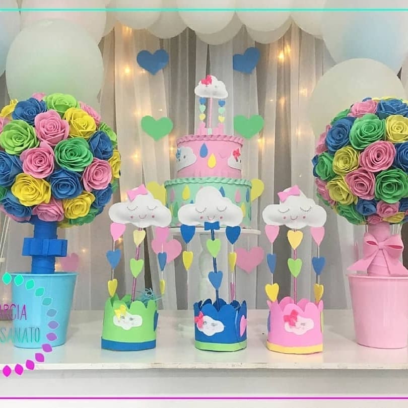 Centros de mesa com nuvens e corações coloridos feitos em EVA, com base decorada em tons pastel, usados em festa infantil com tema Chuva de Amor.