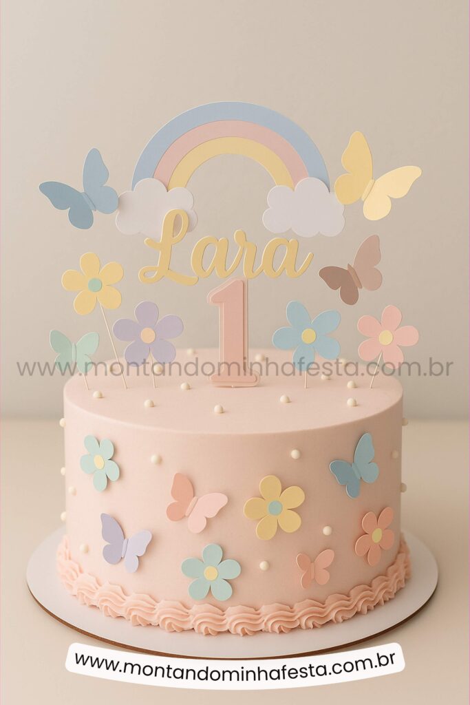 Bolo jardim encantado com arco-íris, flores e borboletas em tons pastéis – decoração delicada para aniversário infantil de 1 ano com nome personalizado.