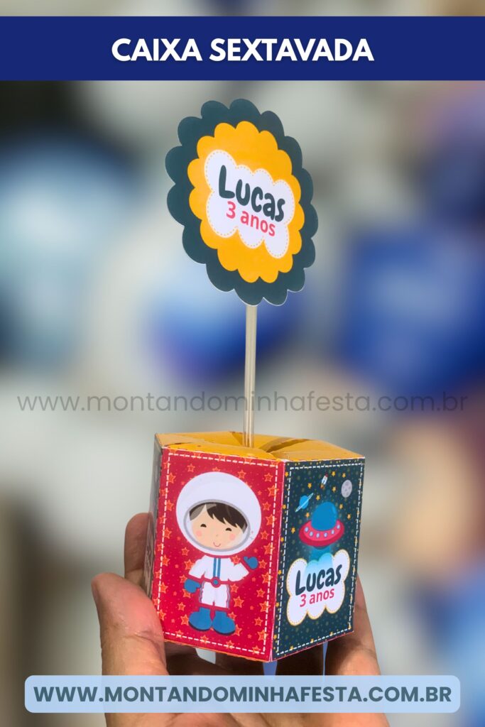 Lembrancinha em formato de caixa sextavada com estampa de foguete e astronauta, personalizada para “Lucas 3 anos”. Produzida com molde digital editado no Canva e cortado com precisão na Silhouette.